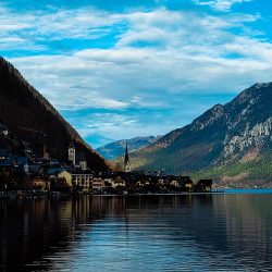 A breathtaking view of Hallstatt, where the charming alpine village meets the tranquil lake, creating a picture-perfect reflection. Surrounded by majestic mountains, this hidden gem of Austria feels like a scene from a fairy tale